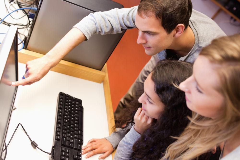 Des camarades de classe utilisant un ordinateur dans une salle informatique